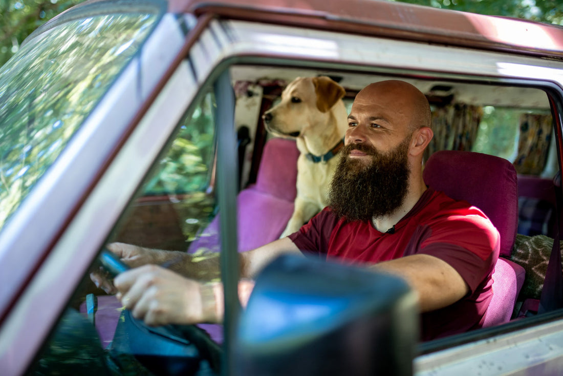 man with a dog in a car while in a roadtrip